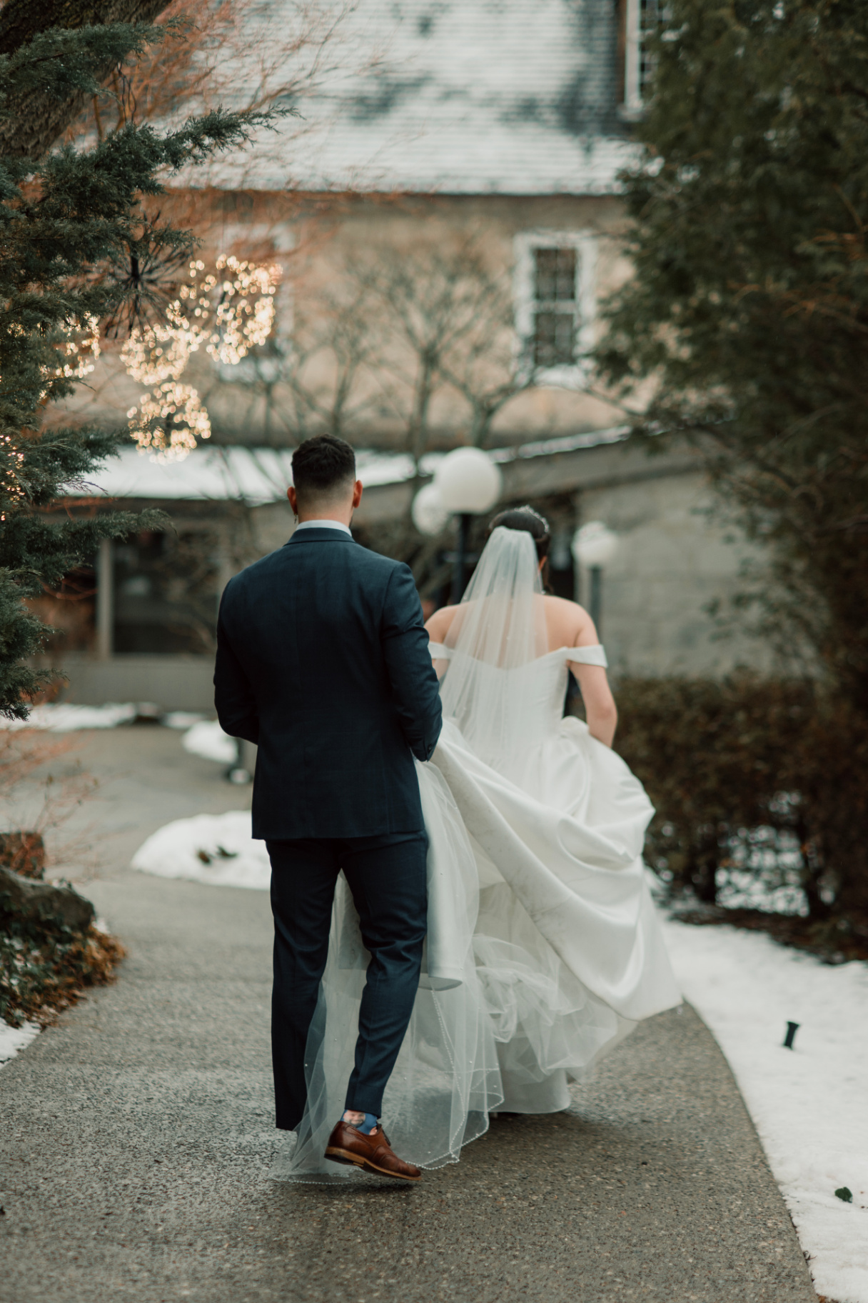 Bride and groom walking through a winter courtyard