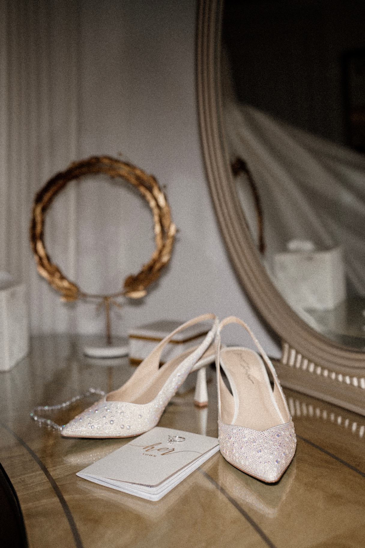 Bridal shoes and vow book on a vanity